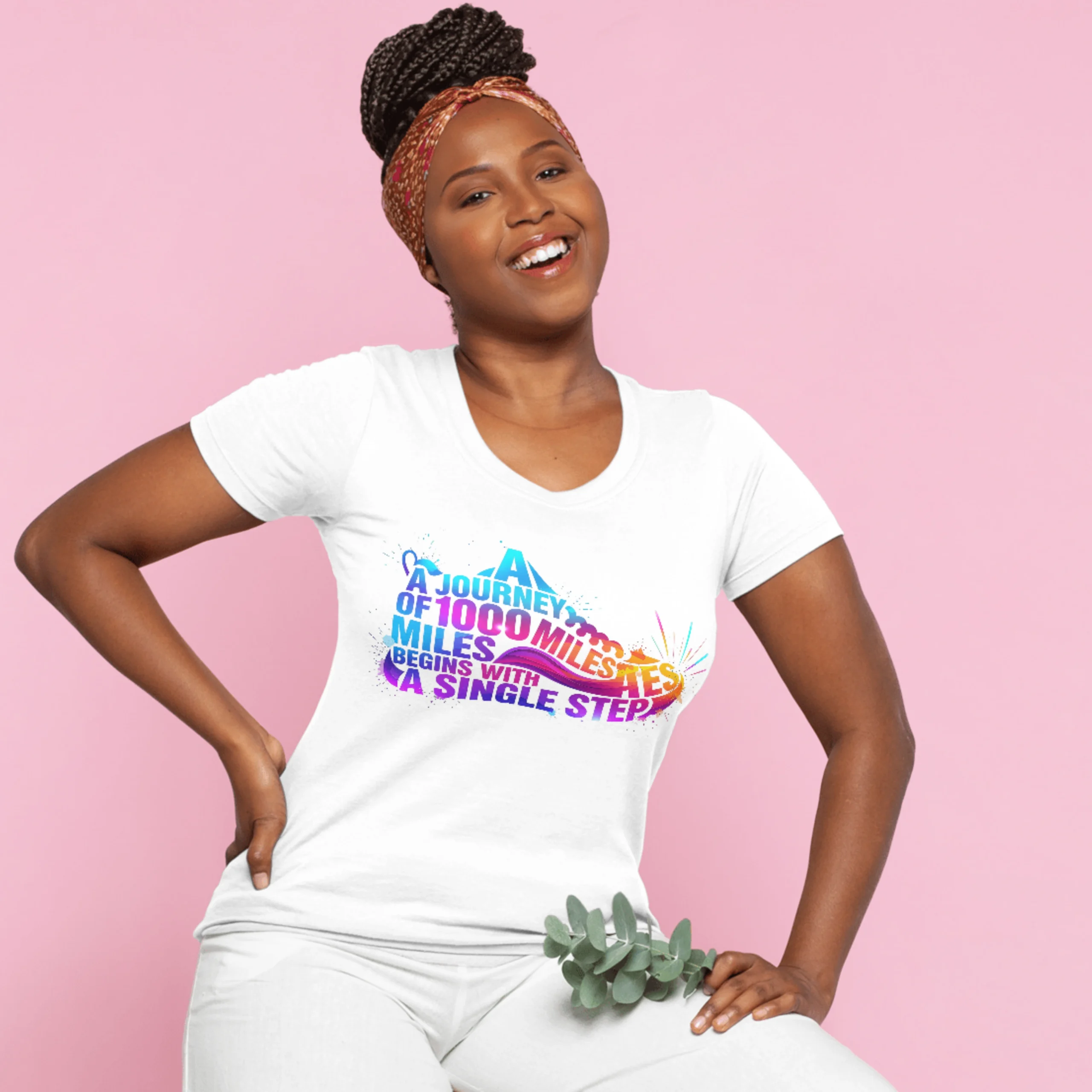 Man and woman modeling the matching QGM 'Journey of 1000 Miles' white unisex graphic tee with a vibrant, colorful running shoe design.